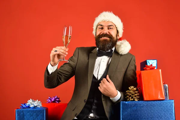 Man met baard houdt champagne op rode achtergrond. — Stockfoto