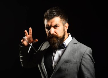 Resmi takım elbiseli maço sakal ve bıyık kesiyor..