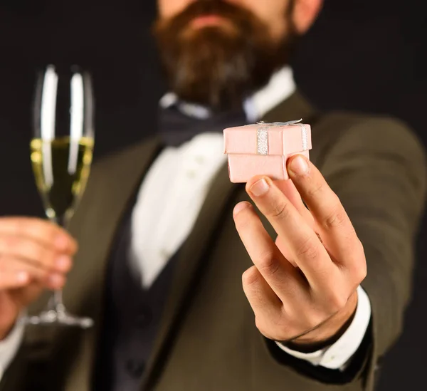Masculino en traje retro presenta pequeña caja rosa sosteniendo bebida —  Fotos de Stock