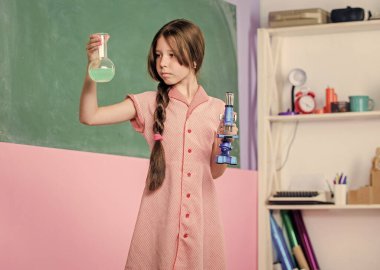 Araştırma ve geliştirme. Kız test tüpüyle kimya okuyor. Okul laboratuarı. Modern teknoloji. Laboratuvar matarası olan küçük bir kız. Mikroskopla fen dersi. Okula dönüyorum. biyoloji eğitimi
