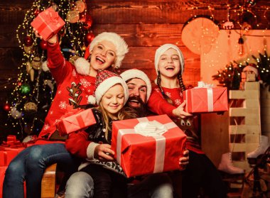 Noel geleneği. Aile bağları aktiviteleri. Noel neşesi. İyi tatiller. Ebeveynler ve çocuklar Noel hediyelerini açıyor. Baba Noel Baba ve anne küçük kızları Noel ağacı geçmişi