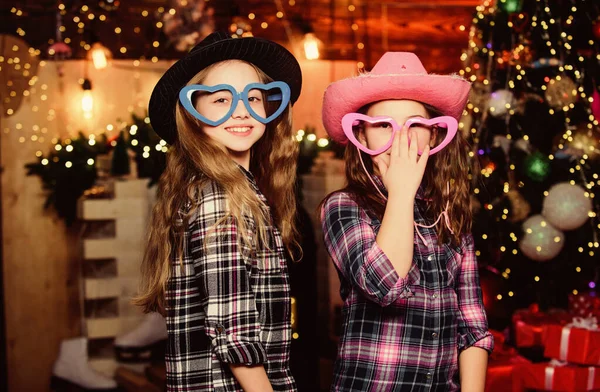 Niños vaqueras. Feliz año nuevo. Árbol de Navidad. Felices fiestas. Hermanitas en sombreros y gafas de vaquero. Feliz navidad. Hermanitas de Santa Claus. Chriatmas interior. Tiempo de Navidad —  Fotos de Stock