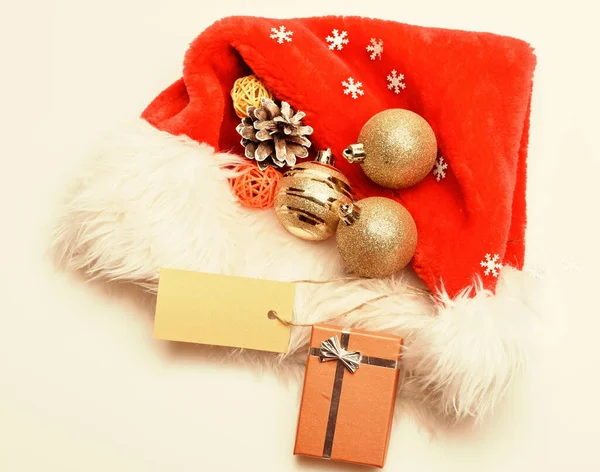 Regalos de Navidad de Santa. Los atributos de las vacaciones de invierno. Año nuevo y la celebración de Navidad. Santa sombrero rojo blanco vista superior del fondo. Sombrero de Santa con caja de regalo de Navidad. Mantener las tradiciones familiares — Foto de Stock