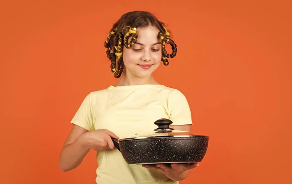 Σίγουρος σεφ. Χαρούμενο παιδί με παστίλιες μαλλιών. νοικοκυριό από την παιδική ηλικία. Μια μικρή γυναίκα κρατάει τον Παν. μαγείρεμα στην κουζίνα. έννοια του νοικοκυριού. το παιδί μαγειρεύει στο σπίτι. Χαρούμενη παιδική ηλικία — Φωτογραφία Αρχείου