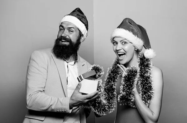 O par alegre celebra o Ano Novo. A dar presentes. Humor festivo. Dia de boxe. Pai Natal secreto. Festa corporativa de Inverno. Festa de Natal do escritório. Escritório de festas de Natal. Homem feliz e mulher usam chapéus de Papai Noel — Fotografia de Stock