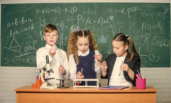 Fascinating chemistry. Basic chemical reactions. Group school pupils study chemistry in school. Boy and girls enjoy chemical experiment. Organic chemistry is study of compounds containing carbon