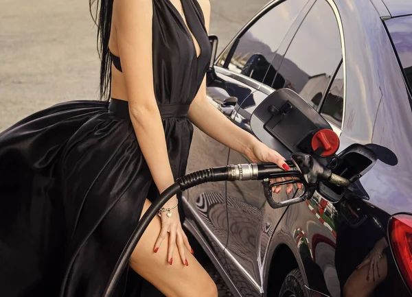 Роскошный автомобиль. Бензин для богатых. Сексуальная женщина заправляет машину бензином. Заправка. Женщина на заправке. Газ и дизельное топливо. Транспорт и транспорт. АЗС. Нефтепродукты — стоковое фото