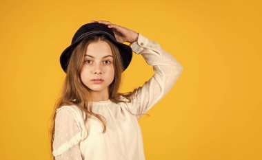 Saf güzellik. Retro şapkalı sevimli küçük çocuk. Eski moda görünüş. Yaz aksesuar koleksiyonu. Küçük çocuk uzun saçlı. Güzellik ve tarz. Kişisel tarzını takip ediyor. Retro kız sarı arka plan
