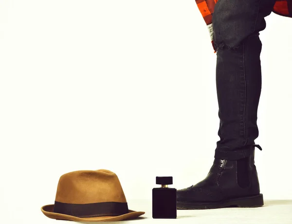 Pierna masculina en jeans, bota con sombrero y frasco de perfume —  Fotos de Stock