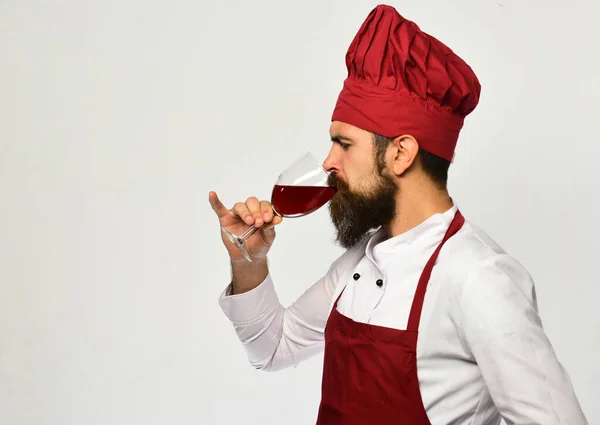 Cook med koncentrerat ansikte i vinrött enhetliga drycker alkohol. — Stockfoto