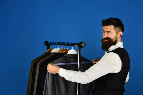 Man met baard in vest door kledingrek. Modekeuze — Stockfoto