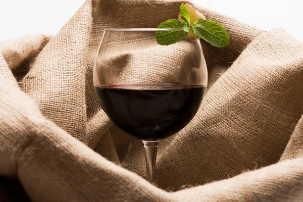 Copo de vinho tinto com pano de saco no fundo — Fotografia de Stock