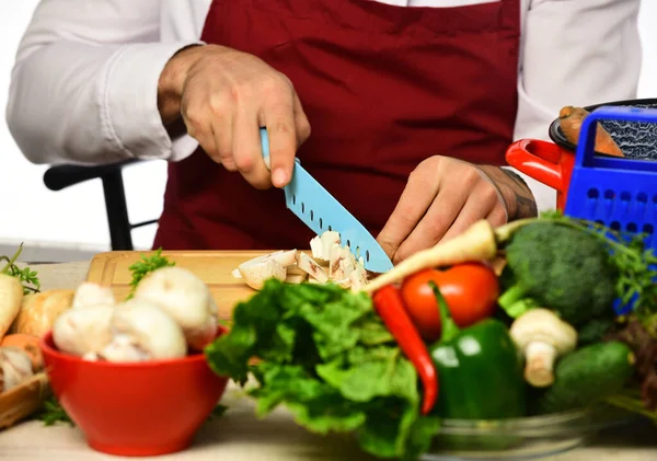Кухар бургундської форми нарізає овочі. Чоловічі руки розрізали гриби — стокове фото