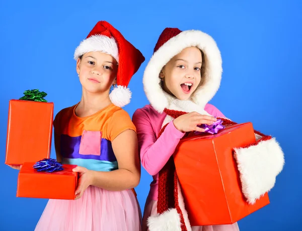 Enfants en chapeaux de Père Noël avec des boîtes cadeaux ouverts cadeaux. — Photo