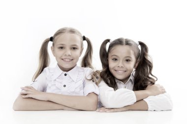 Öğrenmenin başladığı ders. Okul masasında oturan sevimli çocuklar. İlkokulda ders alan küçük liseli kızlar. Sevimli küçük kızlar ders alıyor. Okul dersi.