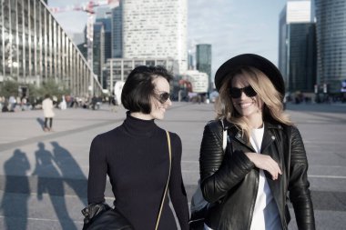 La Defense, Paris 'te kızlar şık kıyafetler içinde gülümserler.