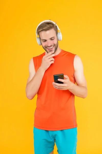 Sportoló fickó fülhallgatóval és okostelefonnal. Férfi fitnesz stílus. férfi headset hallgatni dal edzés. sport és zene. lejátszási lista mp3 lejátszóval. innovatív vezeték nélküli eszköz. edzés. online vásárlás — Stock Fotó