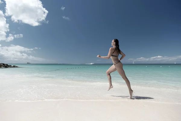 Ragazza in costume da bagno sexy in esecuzione sulla spiaggia di mare — Foto Stock