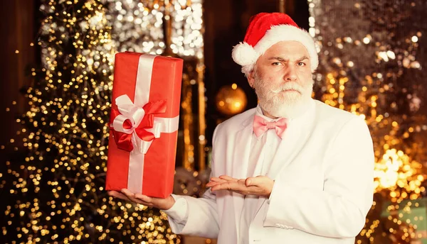 Sé positivo. es navidad. Feliz año nuevo. regalo de Navidad barato y recompensa de negocios. hombre mayor sombrero de santa celebrar caja de regalo. hombre de negocios barbudo llegar presente. decoración de vacaciones e iluminación — Foto de Stock