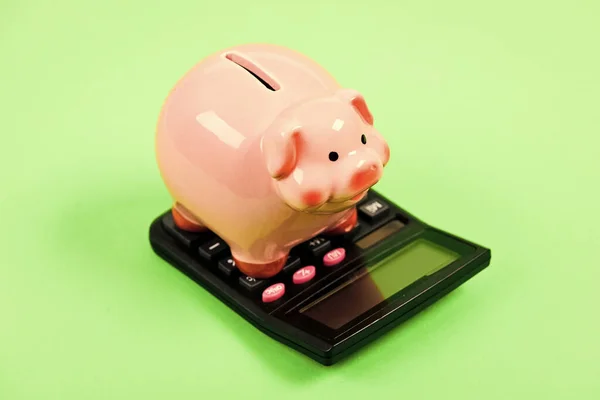 Tax savings. Piggy bank money savings. Investing gain profit. Calculate taxes. Piggy bank pig and calculator. Taxes and charges may vary. Accounting business. Pay taxes. Taxes and fees concept