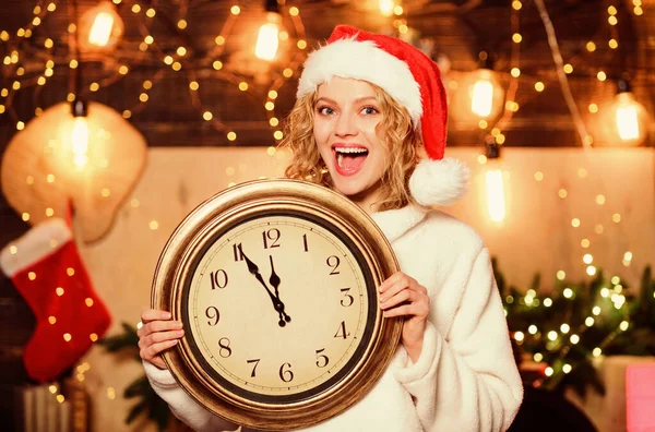 Být překvapený. Vánoční nálada. Žena s hodinami. zimní prázdniny. Je čas na Vánoce. dívka v červeném klobouku Santa Clause. Půlnoc. Veselá ženo, je čas oslavovat. Šťastný nový rok. příprava Vánoc — Stock fotografie