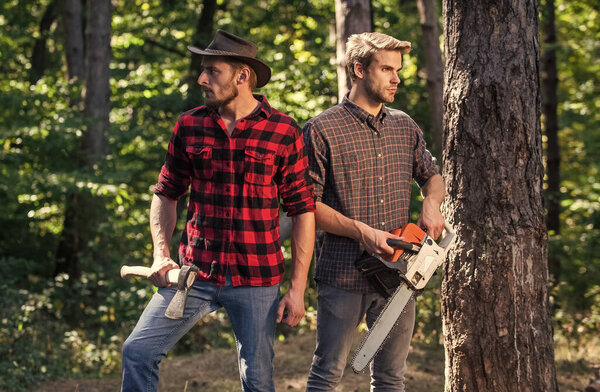 hiking in deep wood. forest care at vacation. summer or spring activity. man farmers relax in forest. rangers use lumberjack equipment. Lumberjack with chainsaw and ax. Harvest firewood