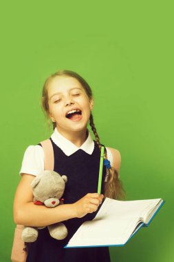 Okul üniformalı çocuk yeşil arka planda izole edilmiş. Konsept çalış