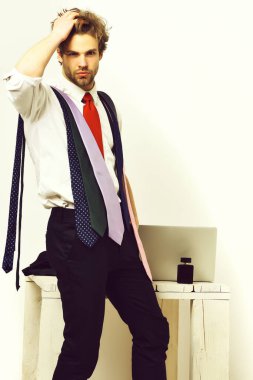 Sakallı, maço, beyaz tenli, renkli kravatlı bir adam.