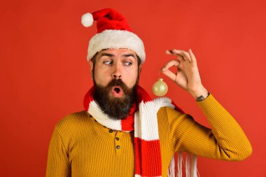 Noel Baba 'nın elinde Noel ağacı süsü var. Sakallı adam