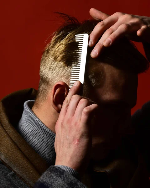 Estilista peinando cabello sobre fondo rojo. Hombre de estilo vintage — Foto de Stock