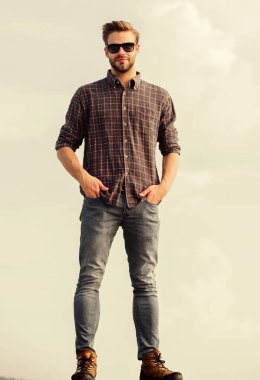 Moda güneş gözlüklü hippi. Ultraviyole koruma kavramı. Erkek gözlüklü model açık havada mavi gökyüzü arka planı. Yakışıklı adam güneş gözlüğü takıyor. Mükemmel görüş. Göz sağlığı. Moda güneş gözlüğü.