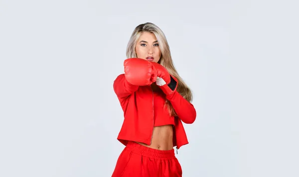 Sport is our life. beautiful woman with red boxing gloves. young sports woman in tracksuit and boxing gloves. blond boxer woman. kick off. confident young sportswoman posing in boxing gloves Stock Picture