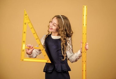 Öğrenci geometri okuyor. Çocuk okulu üniforması cetveli tutar. Geometri dersi. Eğitim ve okul konsepti. Zekice ve zekice bir fikir. Boyut ve boyut. Büyük cetvelli tatlı kız.