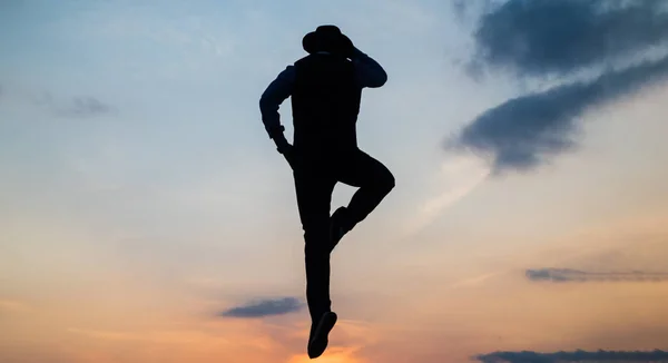 電話やコミュニケーションをしながら日の出の空を飛び跳ねる男のシルエット — ストック写真