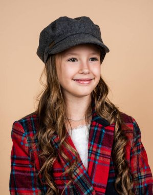 Şık saç stili şapkalı mutlu çocuk. Kareli ceket giyiyor, çocukluk.