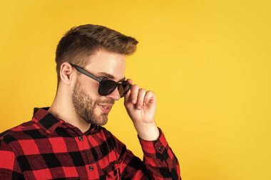 Geleneksel tarzda. Mutlu adam gülümsüyor. Gömlekli yakışıklı bir adamın portresi. Kareli baskılı klasik erkek gömlekleri. Gözlüklü ve gömlekli kendine güvenen bir adam. Boşluğu kopyala