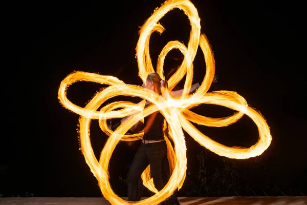 Expressieve stijl paar van vuur dansers spin brandende pois creëren sprankelende patronen op donker buiten, spinners — Stockfoto