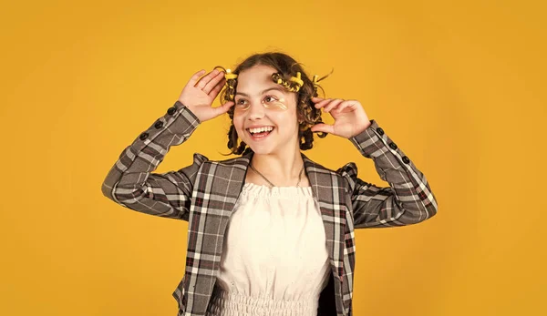 Menina feliz em encrespadores de cabelo jogando salão de cabeleireiro. Dicas fáceis de fazer penteado para crianças. ferramentas de cabeleireiro e acessórios de cabelo. Um miúdo com manchas na cara. posar com encrespadores de cabelo. — Fotografia de Stock
