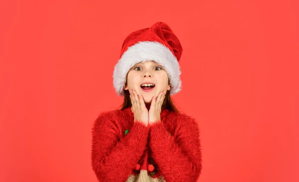 予期せぬ驚きだ。冬休みが好き。クリスマス気分でね。サンタ・ヘルパーの親指が現れる。サンタ・クラスの帽子の赤い背景の女の子。新年会の準備はいいか?。クリスマス私の好きな休日 — ストック写真