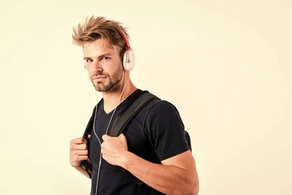 Enjoy music everywhere you go. Download music application. Youth music taste. Student handsome guy listening music. Modern people concept. Man tousled hairstyle wear plastic earphones gadget