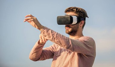 İş dünyasında yenilik. Erkek gerçekliği. VR kulaklığı kullan. Adam kablosuz sanal gerçeklik gözlüğü takıyor. Kendi işini kur. Dijital gelecek ve yenilik. Seksi adam gökyüzü arkaplan gözlüğü