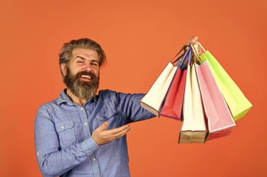 Evden alışveriş. Elektronik mağazasından alışveriş yapan son derece mutlu bir hippi. Alışverişten hoşlanan olumlu bir adam. Kendi işim var. Sakallı adam kese kağıdı tutuyor. Hediyeler. Online alışveriş yapmaktan memnun oldum.