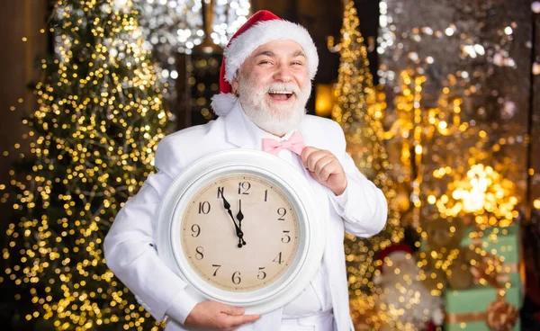 Happy New Year. wait for xmas presents. santa man hold alarm clock. new year midnight. clock showing almost midnight. time to celebrate winter holidays. hurry up. Christmas countdown arriving