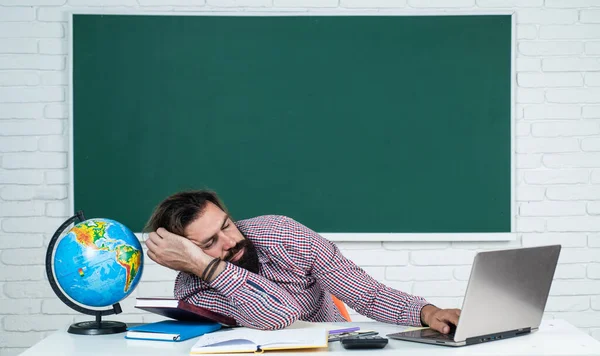 ทํางานหนักเกินไปในขณะที่เตรียมตัวสอบ อาจารย์วิทยาลัยในบทเรียนพักผ่อน กลับไปโรงเรียน การศึกษาที่ไม่เป็นทางการ ครูผู้ใหญ่นอนหลับพักผ่อนบนโต๊ะ ผู้ชายเคราโหดร้ายนอนในห้องเรียนกับกระดานดํา — ภาพถ่ายสต็อก