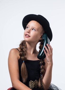 Güzel konuşmaydı. Geçmişi olan neşeli kız beyazda izole edilmiş görünüyor. Çocuk modası. Çocuk retro telefonda konuşuyor. Güzellik ve moda. Arkadaşımla konuşuyorum. çocukluk mutluluğu. Çağrıya cevap ver