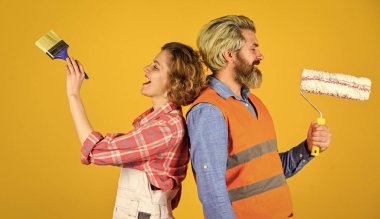 Duvarları boyuyorum. Neşeli çift evi yeniliyor. Kadın müteahhit. Erkek ressam ya da dekoratör. İç yenileme. Dekorasyon dairesi. Rengi seç. DIY onarımı. İnşaat işçileri. Ev yenilenmesi