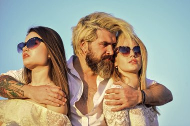 İkisine de aşığım. Çatıdaki partiden arkadaşlar. Havalı hipster ve kadın beyaz elbiseler. Kadınlar ve erkek arkadaşlar sarılıyor. - Aile. Yaz tatili. İlişkiler dostluk romantizmi. Üçlü konsept