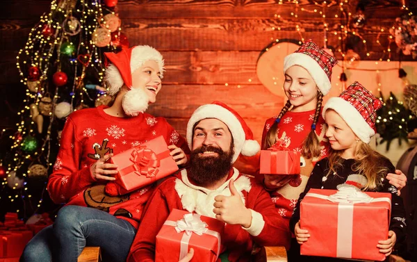 Tradición navideña. Pasa tiempo con tu familia. Padres e hijos abriendo regalos de Navidad. Día de boxeo. Padre barbudo hombre y madre con hijas lindas fondo del árbol de Navidad. Felices fiestas — Foto de Stock