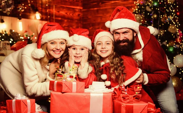 Έρχεται το Νέο Έτος 2020. Ευτυχισμένη οικογένεια γιορτάζουν το νέο έτος. Καλά Χριστούγεννα. Οι γονείς λατρεύουν τα παιδιά. Μικρά παιδιά και γονείς με καπέλο 'γιου Βασίλη. Πολλά χριστουγεννιάτικα δώρα. Πορτρέτο αγάπης οικογένεια — Φωτογραφία Αρχείου