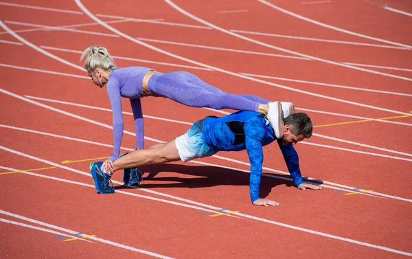 Fekvőtámasz gyakorlat. Edzés kihívás. Mag izmok deszkája. Az egészség az élet. Segítség és támogatás. sportos emberek. férfi és nő sportedző. fitness pár tréning együtt. nyomja fel a testmozgás — Stock Fotó